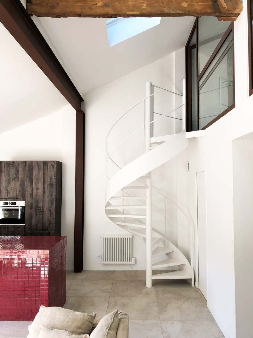 Escalier hélicoïdal blanc vers la mezzanine