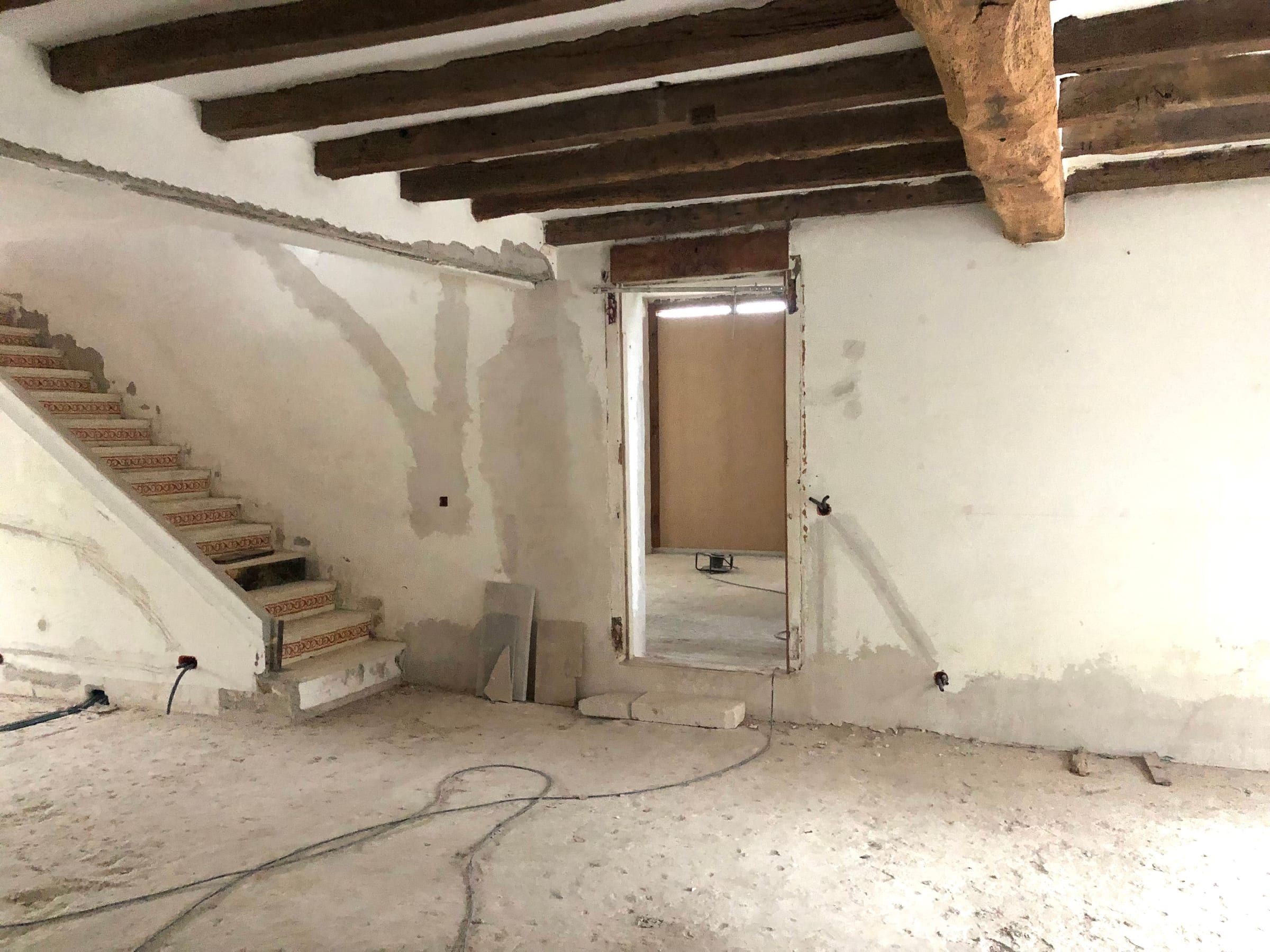 Intérieur avant travaux, poutres et escalier dépouillés