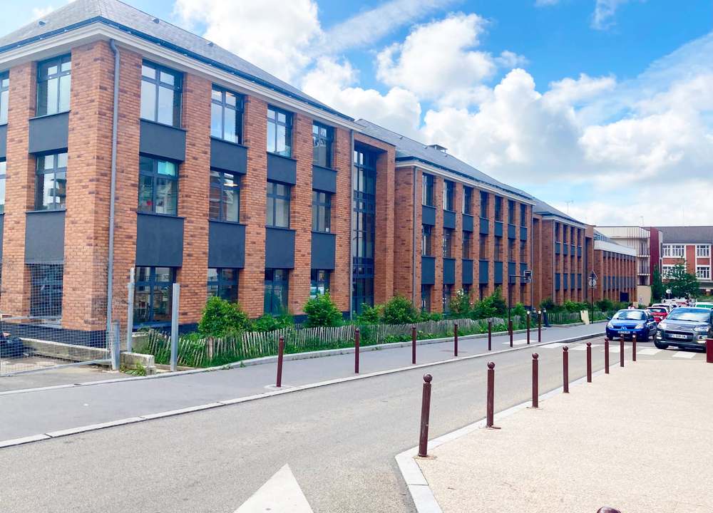 Façade de briques du siège sur la rue, bandeaux de menuiseries sombres