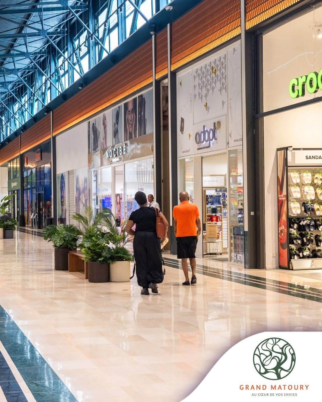 Galerie marchande lumineuse, sol clair et boutiques