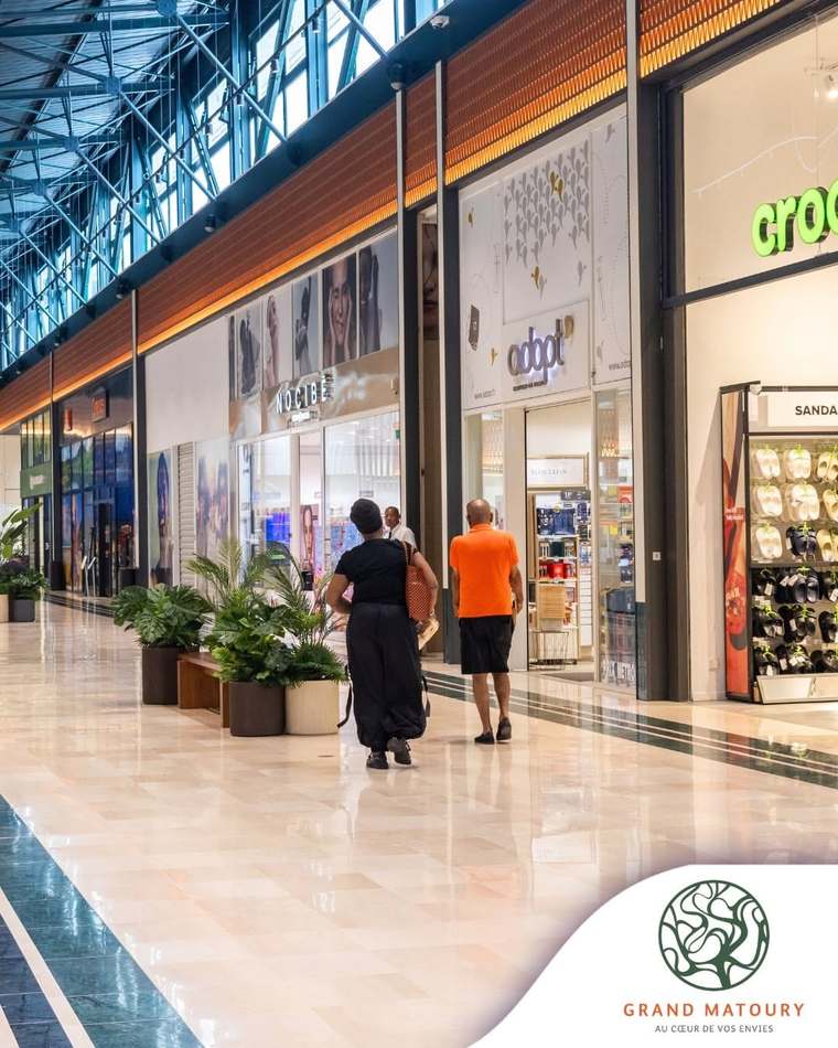 Galerie marchande lumineuse, sol clair et boutiques